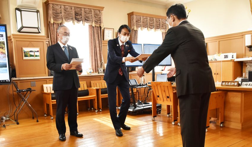 目録を大野知事（右）に手渡す埼玉りそな銀の福岡社長（中央）とりそなAMの西岡明彦社長（10月26日、埼玉県庁、）